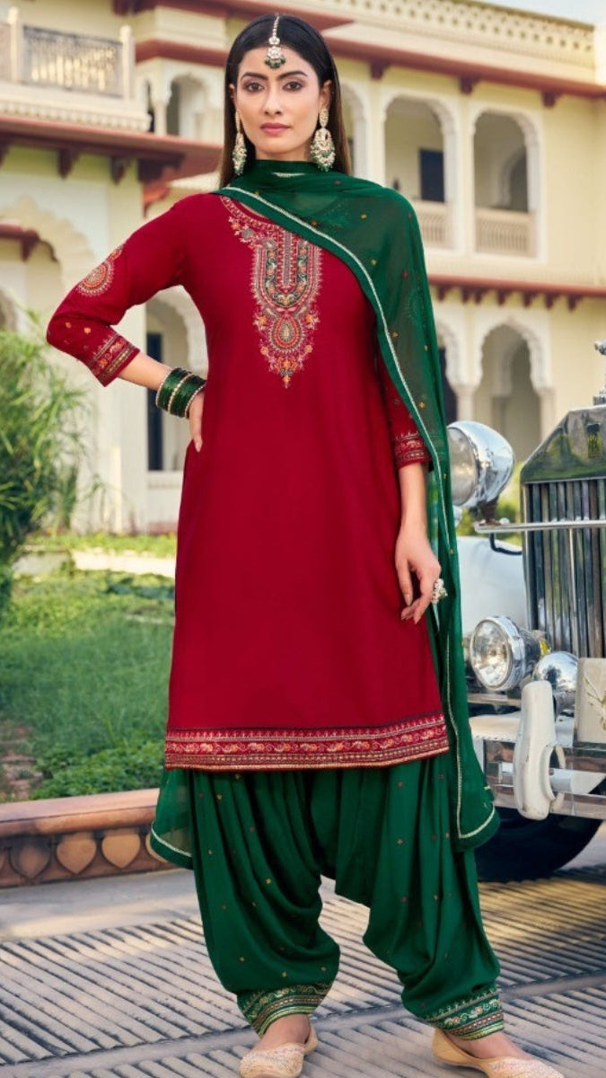 Woman in a red and green traditional outfit standing in front of a vintage car.