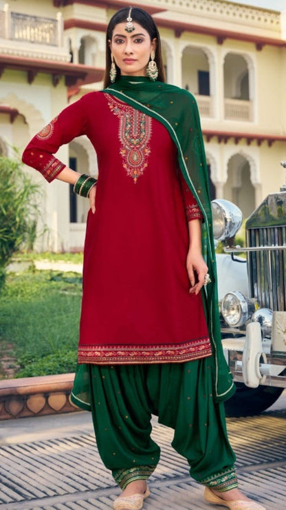Woman in a red and green traditional outfit standing in front of a vintage car.